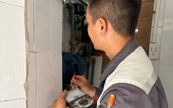 Thợ dùng đồng hồ đo kiểm tra điện bị rò