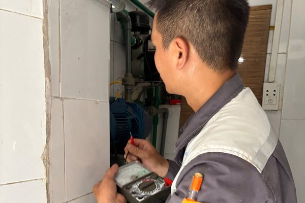 Thợ dùng đồng hồ đo kiểm tra điện bị rò
