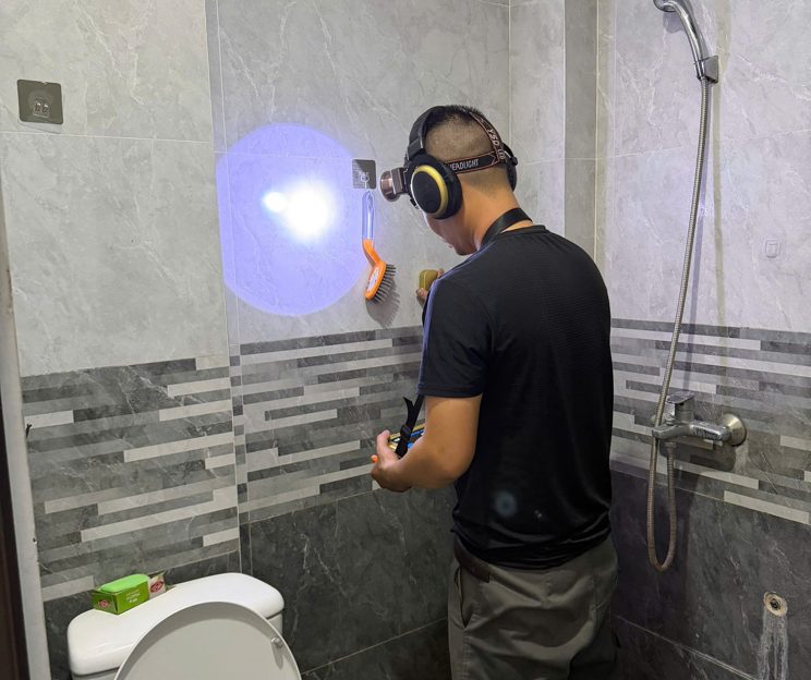 Thợ dùng máy dò tìm rò rỉ nước trong nhà tắm