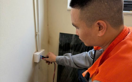 Thợ dùng đồng hồ đo kiểm tra ổ cắm không có điện