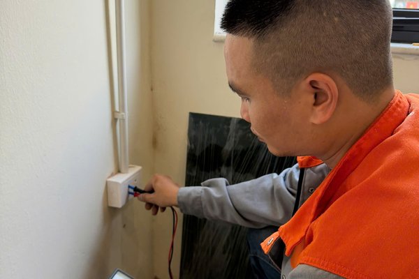 Thợ dùng đồng hồ đo kiểm tra ổ cắm không có điện