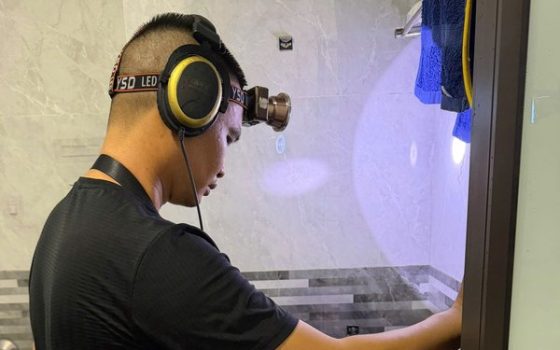 Thợ dùng thiết bị dò kiểm tra ống nước bị rò rỉ trong nhà tắm