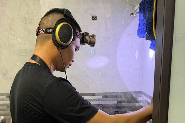 Thợ dùng thiết bị dò kiểm tra ống nước bị rò rỉ trong nhà tắm