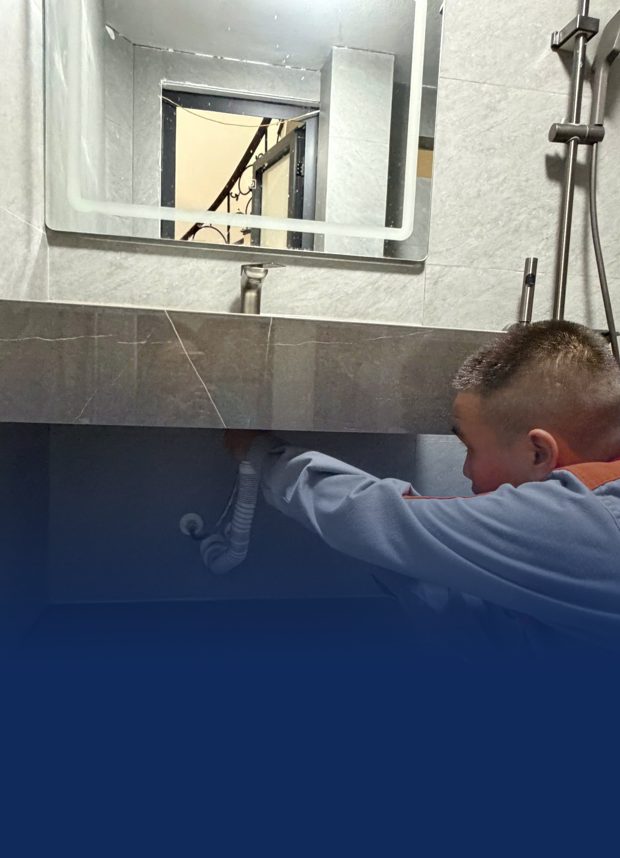 Thợ sửa ống nước dưới chậu lavabo